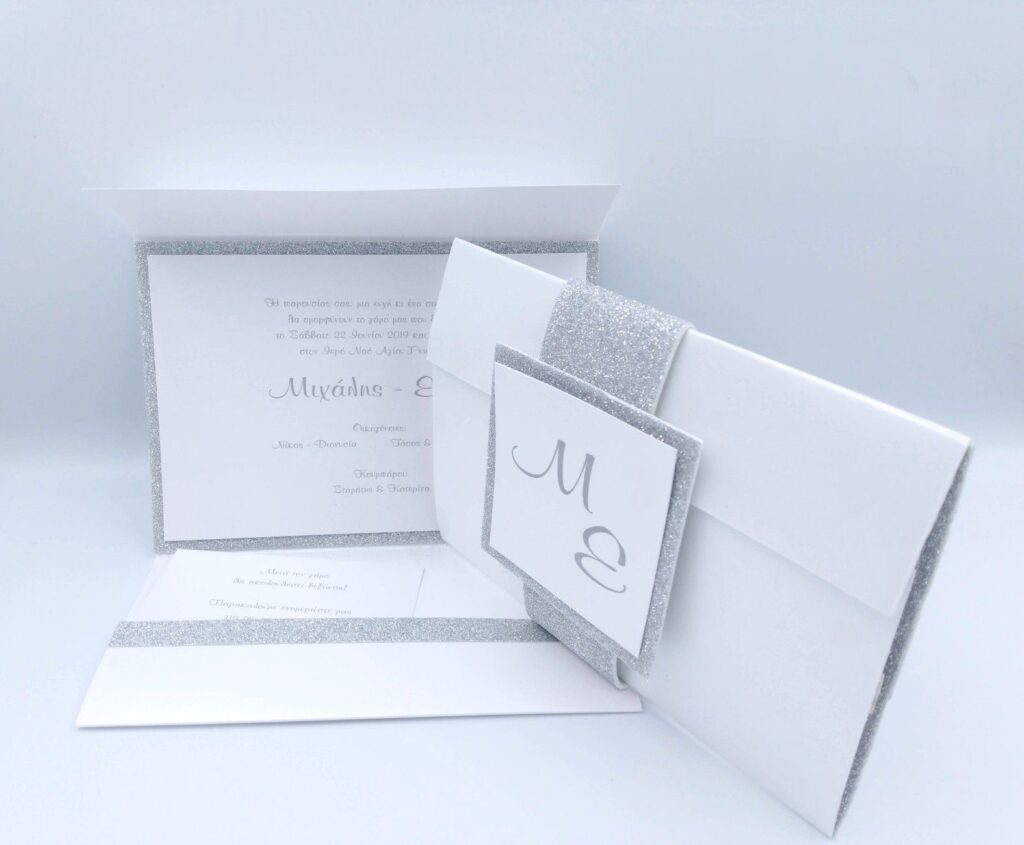 Προσκλητήρια γάμου πολυτελείας U025 glitter silver λευκό με γκλίτερ, ασημί λεπτομέρειες και μονογράμματα, της εταιρίας NewAge invitations